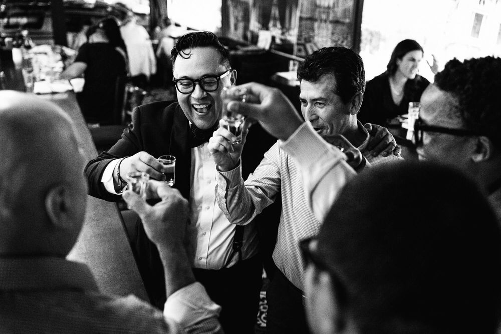 The groom enjoys a toast with his gentlemen during a restaurant wedding reception at Aperitif on Long Island NY.