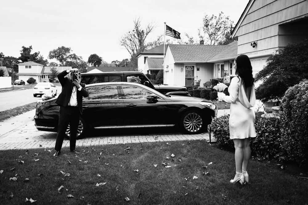 The groom uses a vintage Polaroid Land Camera to make a portrait of his bride on the morning of their wedding day.