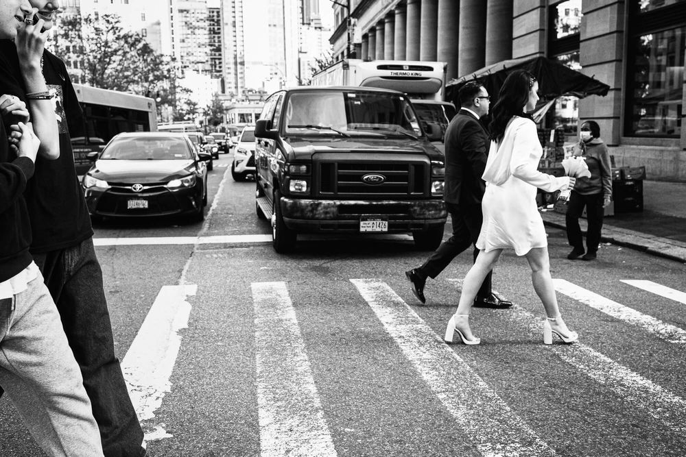 A street photograph of the bride and groom crossing the street at Brooklyn City Hall on the way to wedding ceremony.