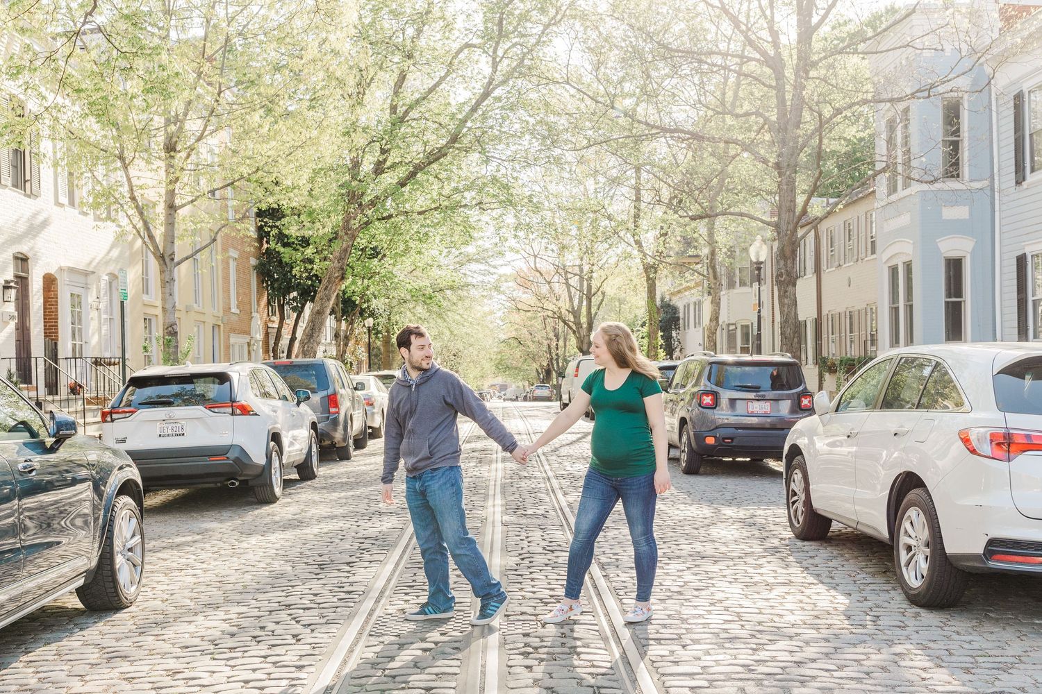A playful moment captured on a historic cobblestone street in springtime.