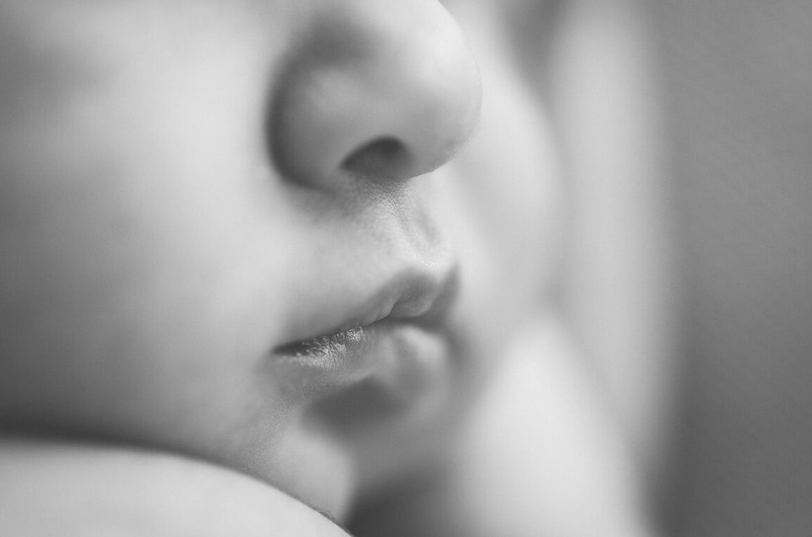 Close up black and white macro photograph of lips and nose in soft focus creating a dreamy effect.