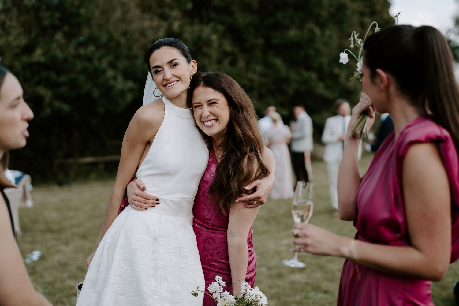 bride hugging bridesmaid on the lawn in islip, oxfordshire