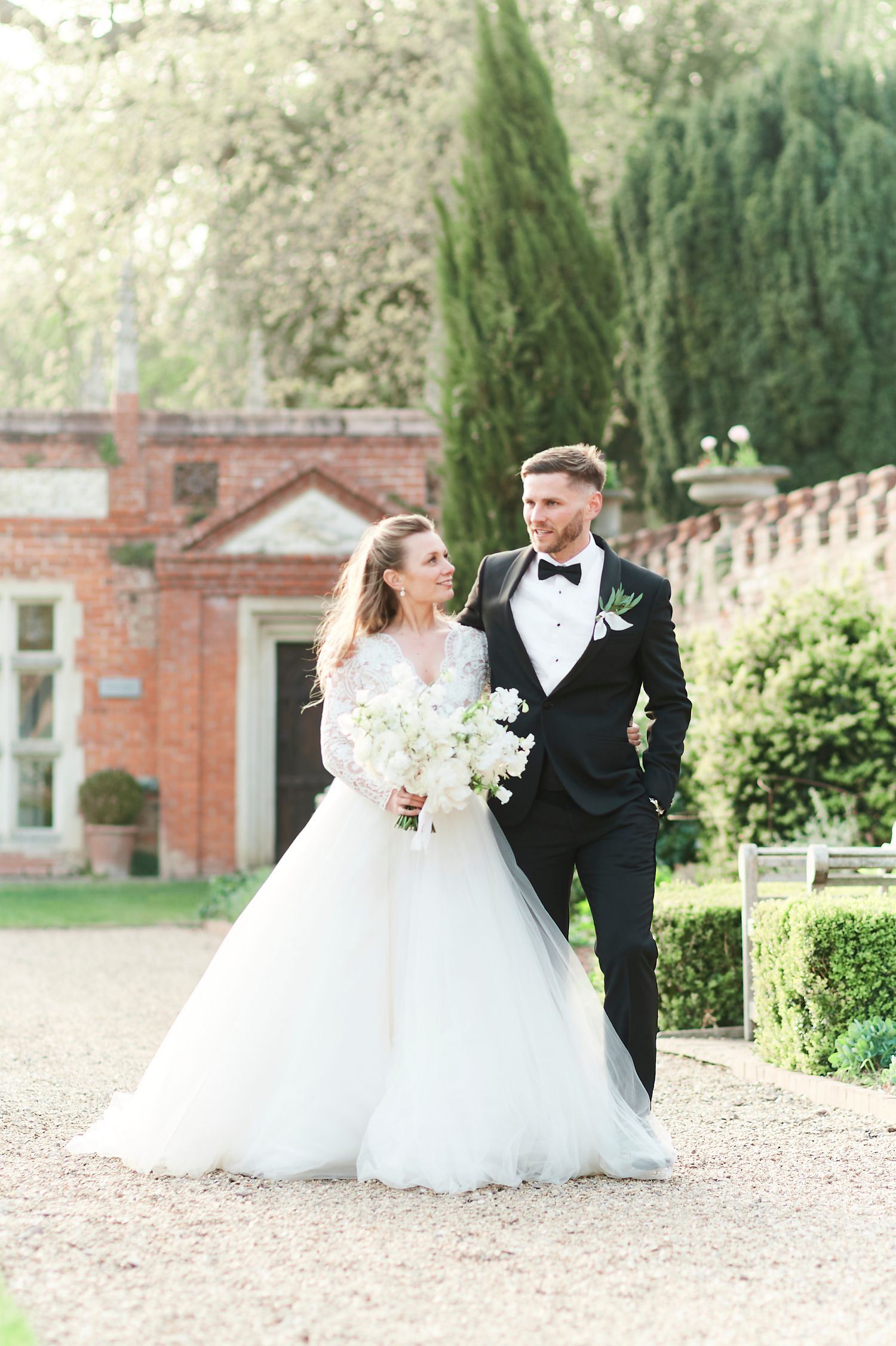 Luxury Bride and groom walking through the beautiful gardens of Oxnead Hall in Norfolk
