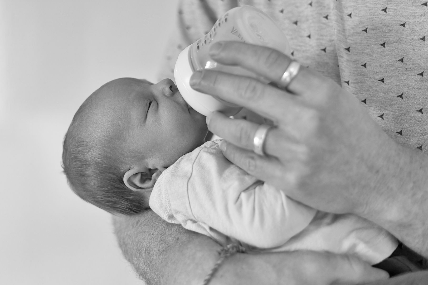 papa geeft flesje in zwart wit, newborn fotografie, baby shoot, Barbara Kempeneers Fotografie