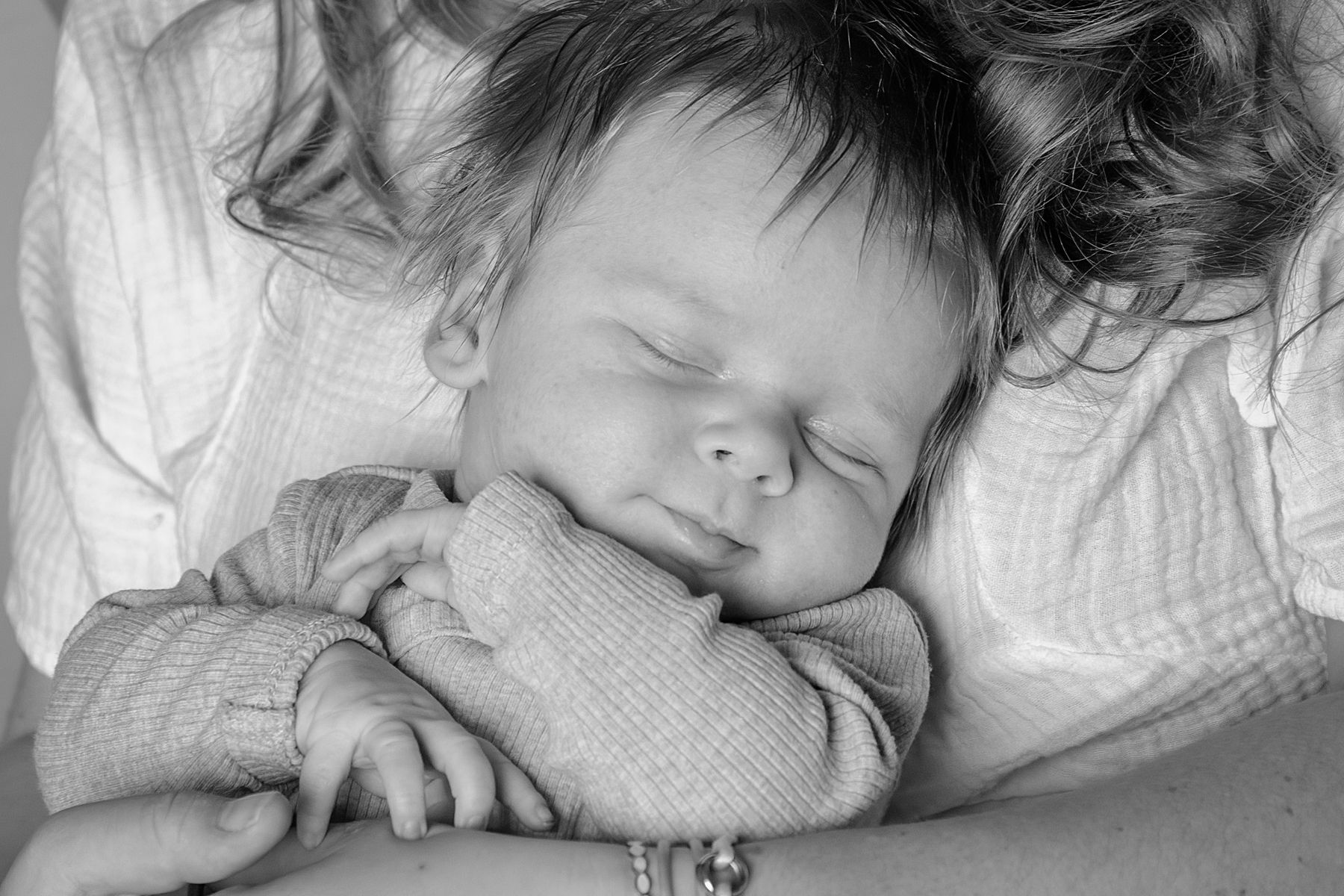 Baby met oogjes dicht bij mama op de arm in zwart wit, newborn fotografie, baby shoot, Barbara Kempeneers Fotografie