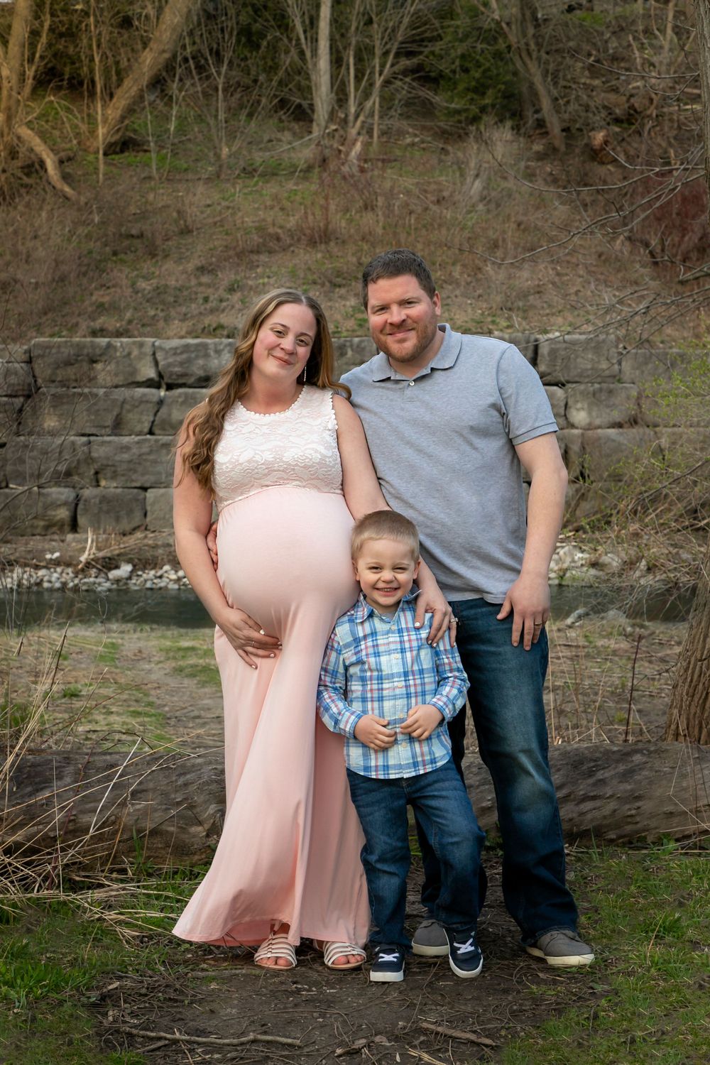 A maternity shoot at the bowmanville creek. Mom is pregnant with Twins, wearing a pink dress. Family shot with their son.