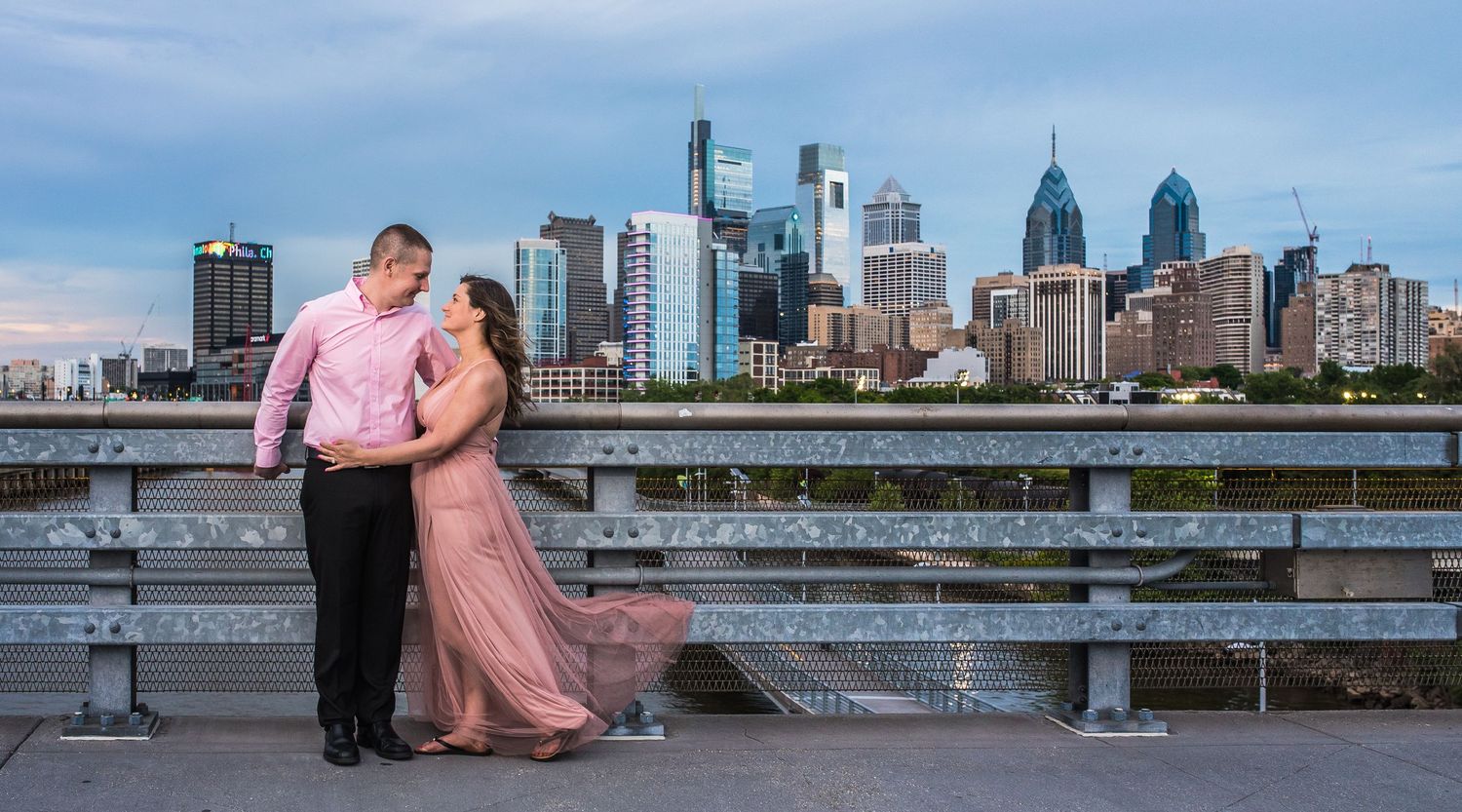 Couple in formal wear photographed against Philadelphia city backdrop.