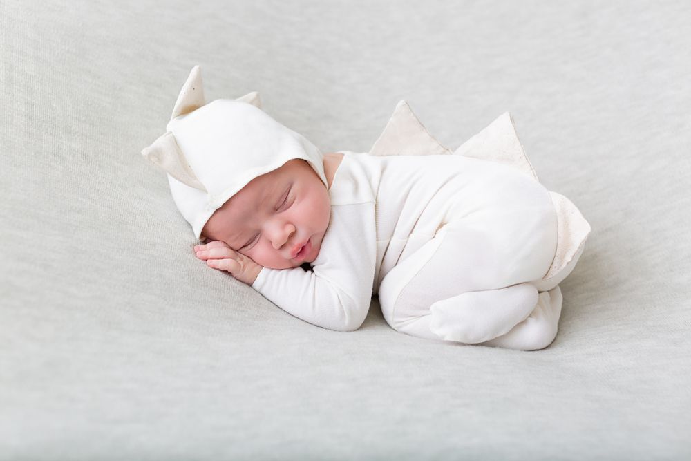 Series of minimalist newborn portraits in white wrap against light background.