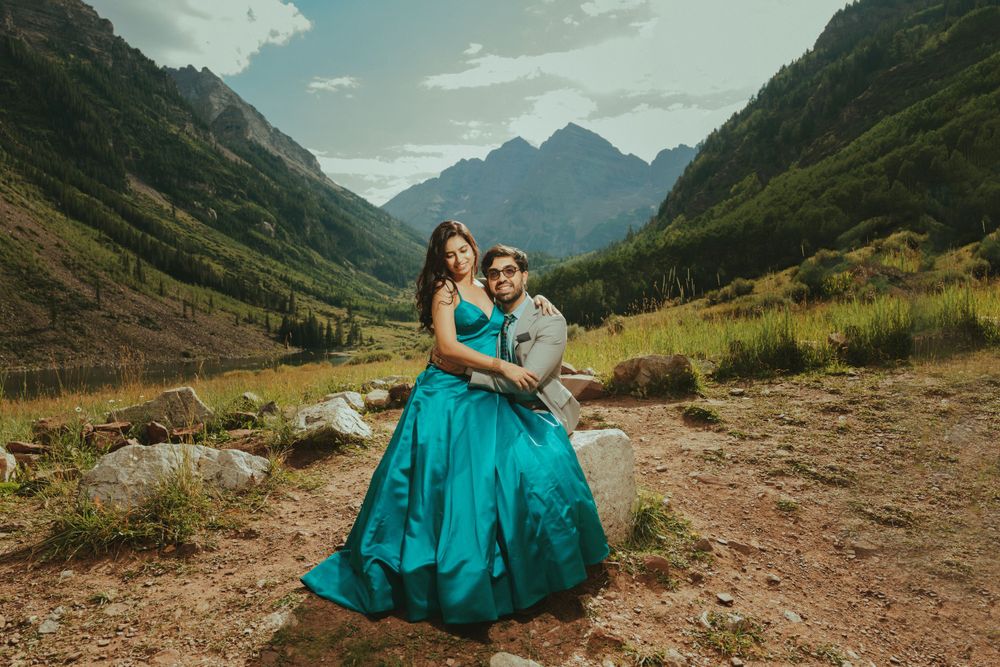A romantic mountain valley engagement photo featuring a flowing turquoise gown.