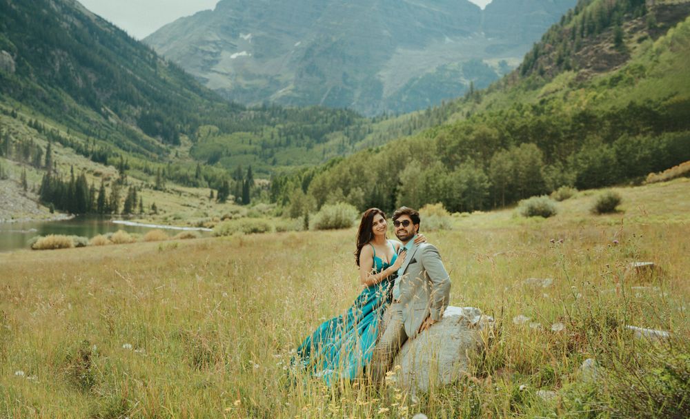 A couple poses in formal wear amidst the majestic mountain valley landscape.