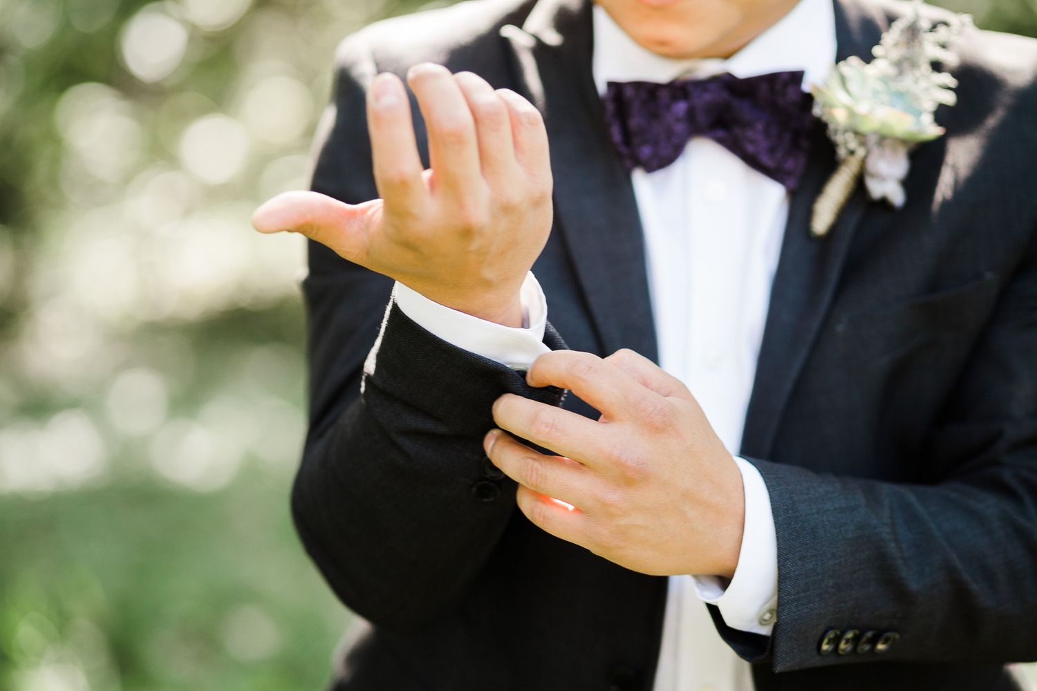 Groom fixing cuffs by Hudson Valley photographer