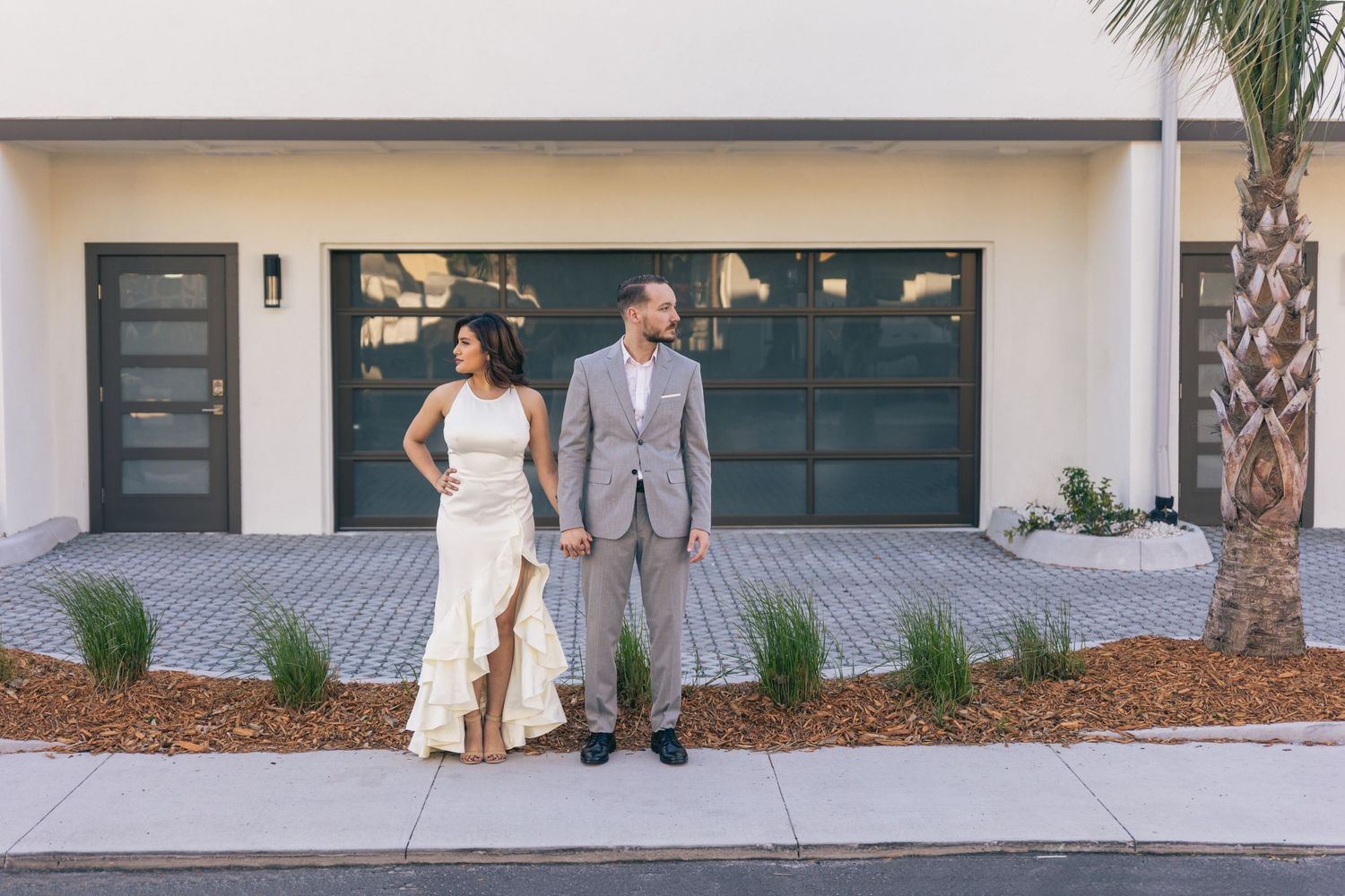 Couple standing holding hands looking opposite ways from each other