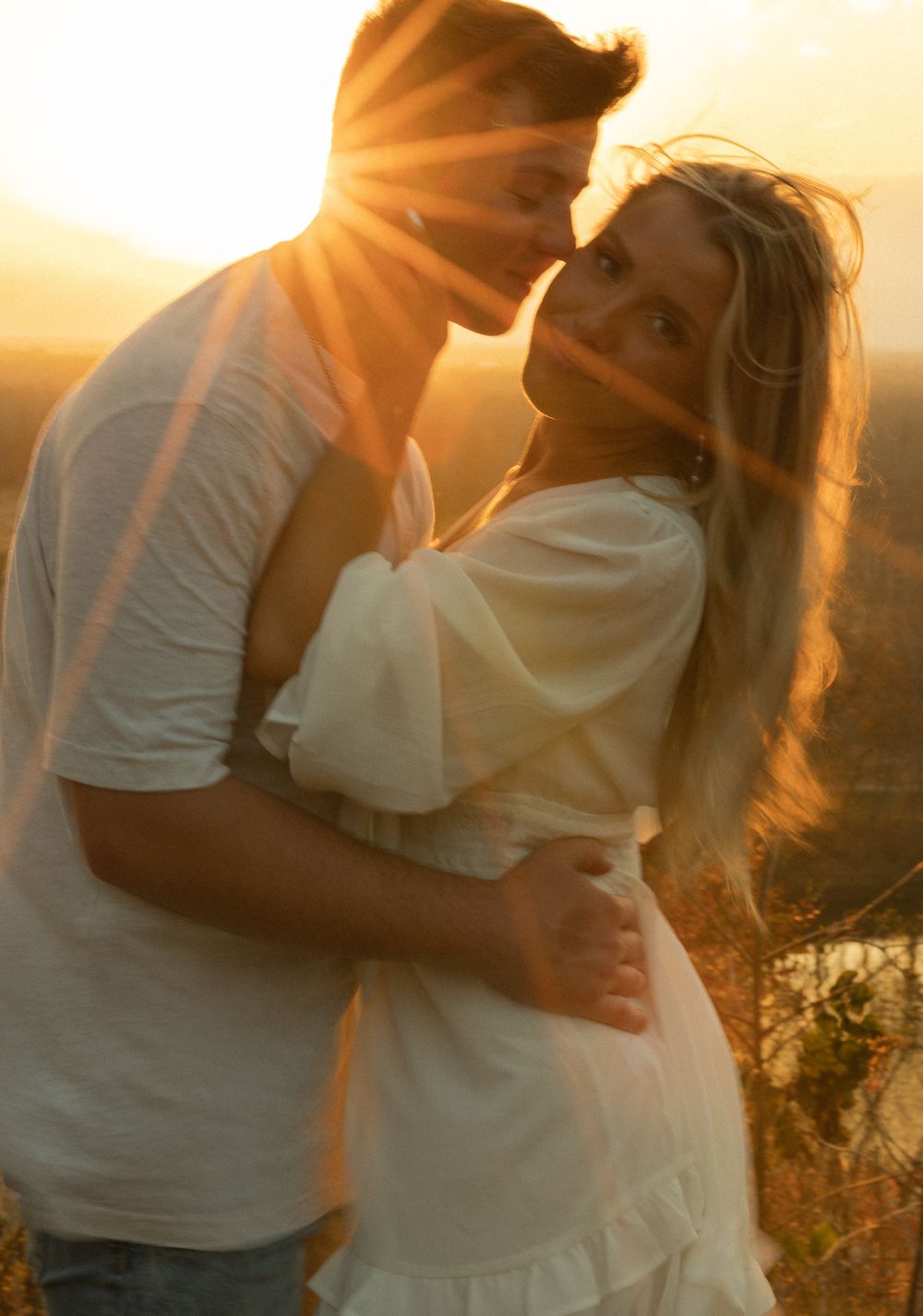 A tender moment between two people backlit by golden sunset light.