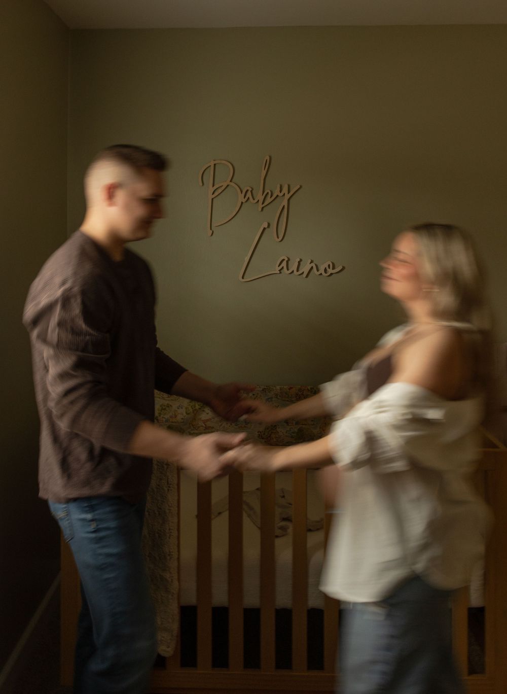 A blurred motion photo of a couple dancing in front of text reading 'Baby Luna' on a wall.