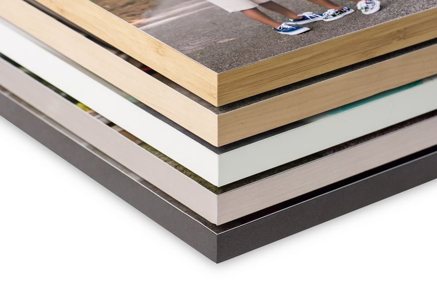 Stack of photo albums or books showing different frame thicknesses and materials.