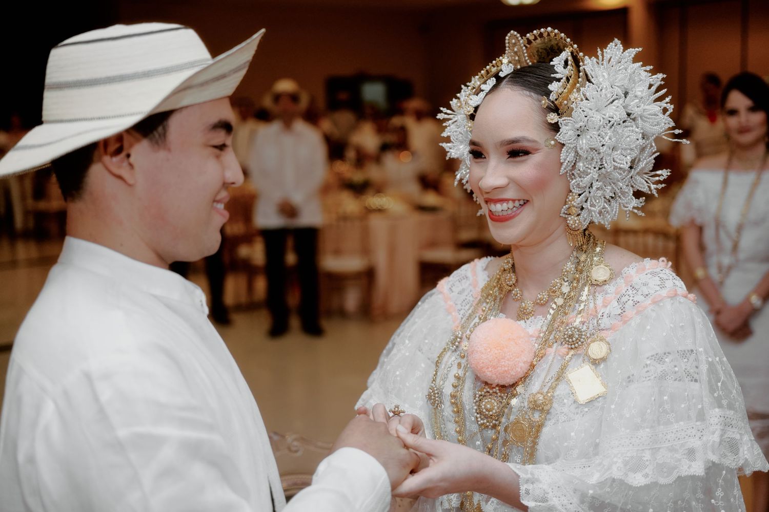 Couple in traditional Filipino wedding attire sharing intimate moment during ceremony.
