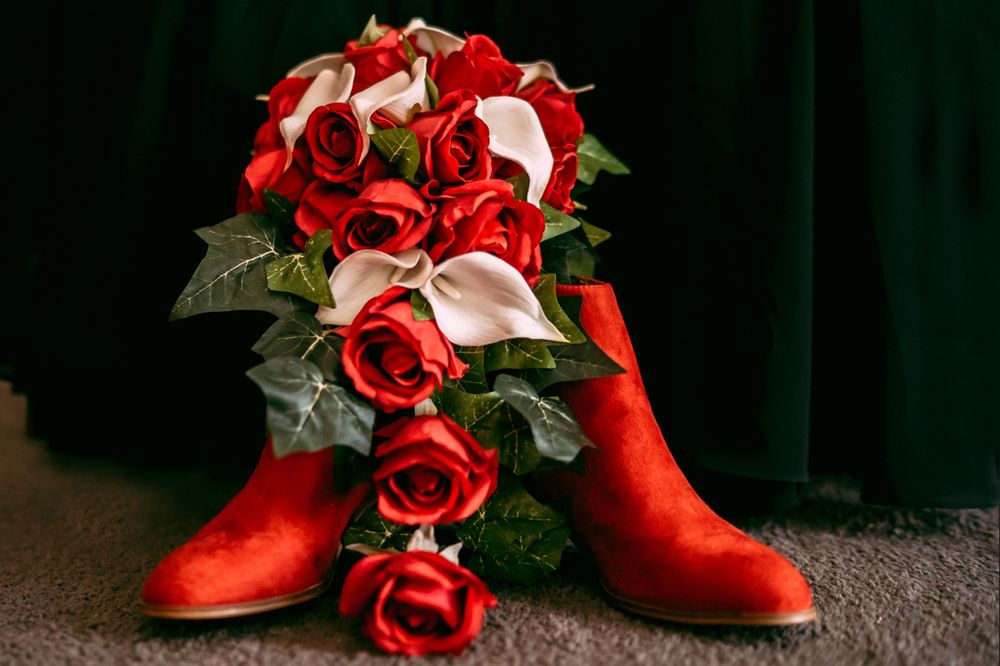 Red satin boots with romantic rose and calla lily bouquet arrangement.