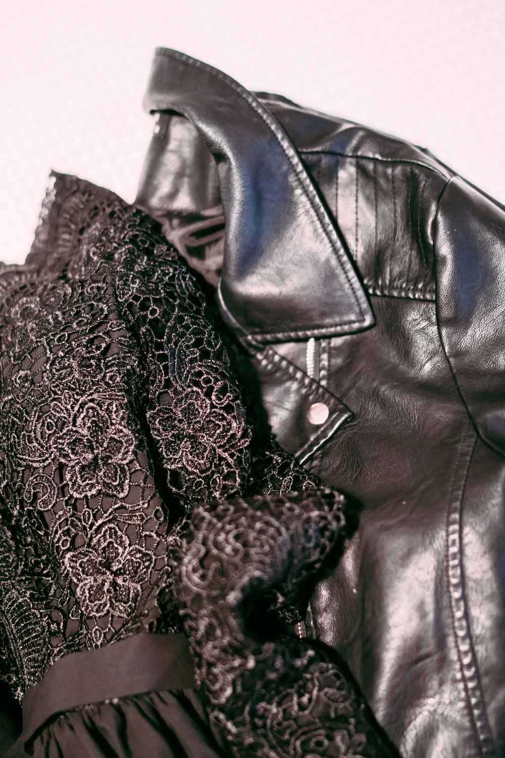 Close up of black lace fabric and leather jacket textures.