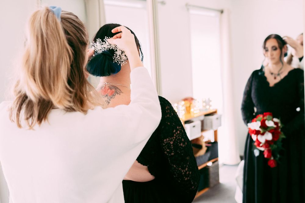 Wedding preparation scene with makeup being applied in a bright indoor setting.