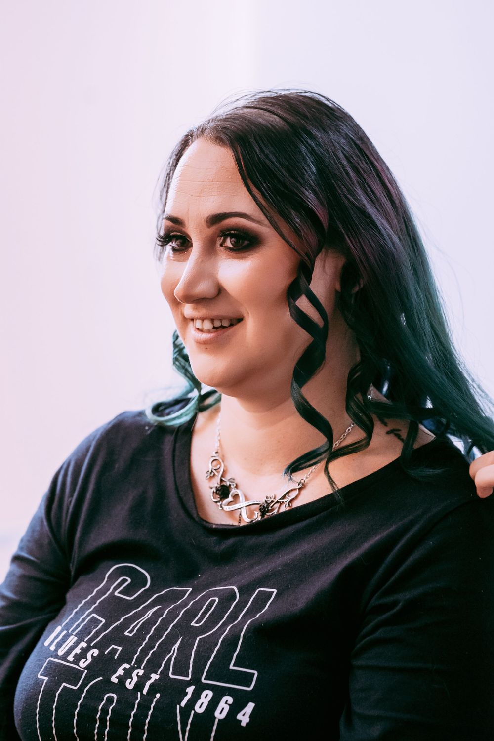 Alternative style female in casual dark attire with dramatic makeup.