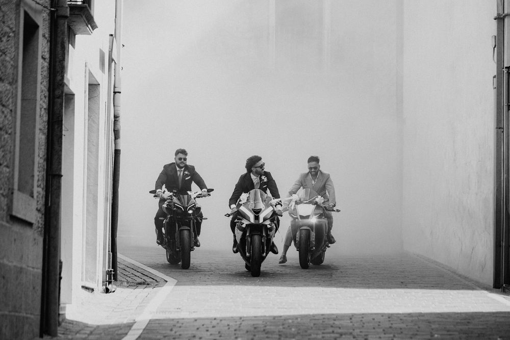 Lorenzo arriva in moto con altri due motociclisti, in una fotografia in bianco e nero.