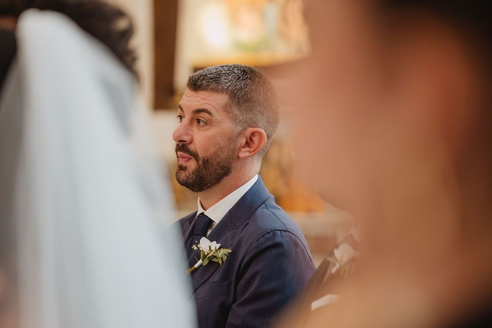 Il volto di Lorenzo durante la cerimonia, tra i volti degli invitati.