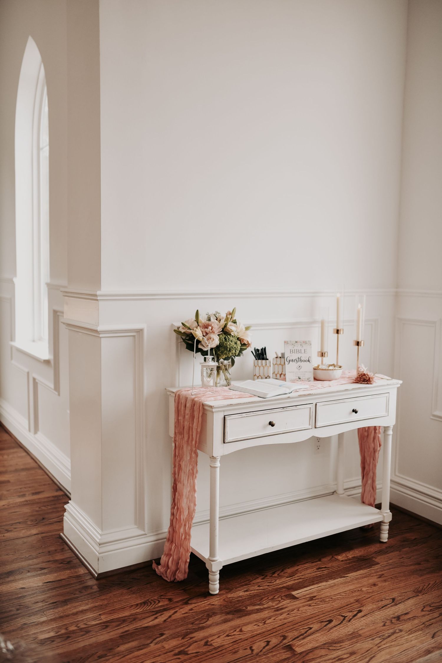 Elegant white wedding chapel with wooden pews and soft pink fall flowers