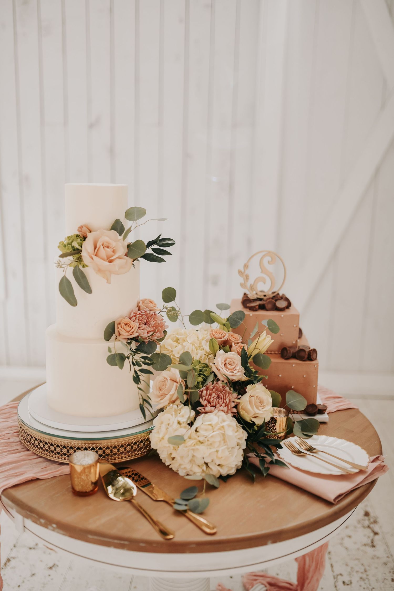 Elegant three-tier white wedding cake decorated with romantic fall flowers