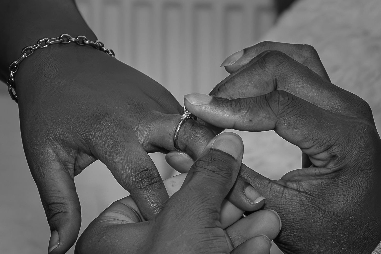 Black and white photo of a person placing a ring on another persons finger, symbolising an engagement or wedding ceremony. Rotherham