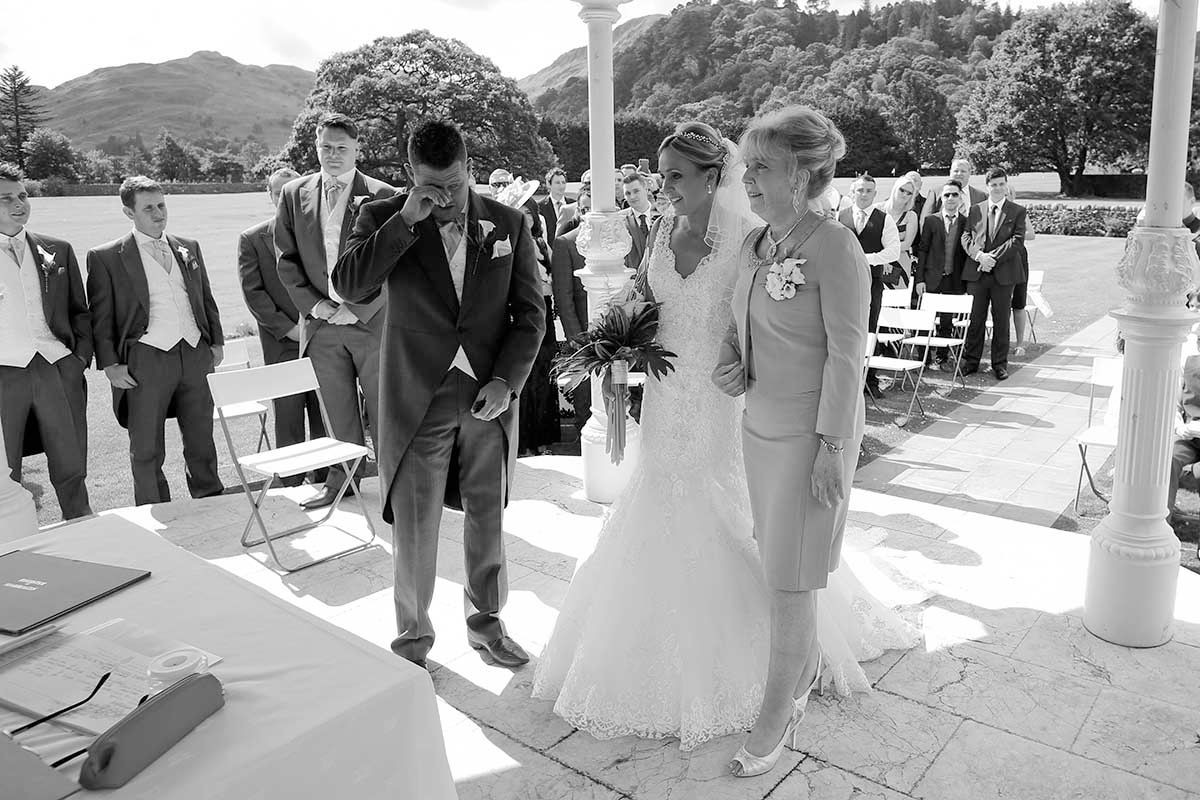 Black and white outdoor wedding ceremony with bride in white gown, groom at the Inn on the Lake