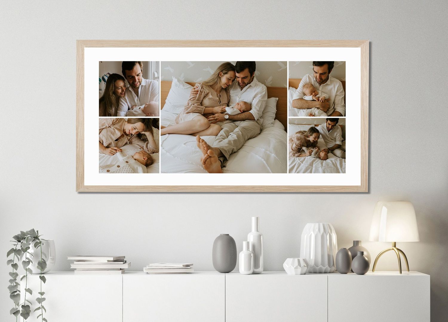 Framed newborn family photo collage above a white console with decor, showing parents cradling their baby in a bright, cozy bedroom.