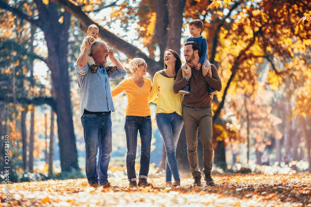 Family playing and having fun in a colorful autumn forest.