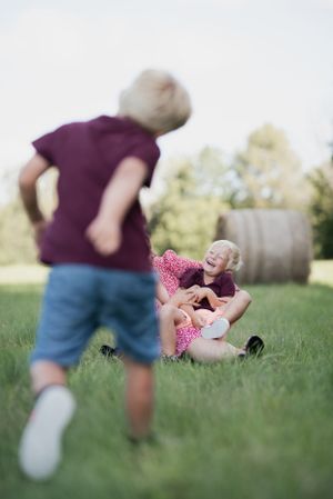 Candid outdoor moment with motion blur capturing play and joy in a grassy field.