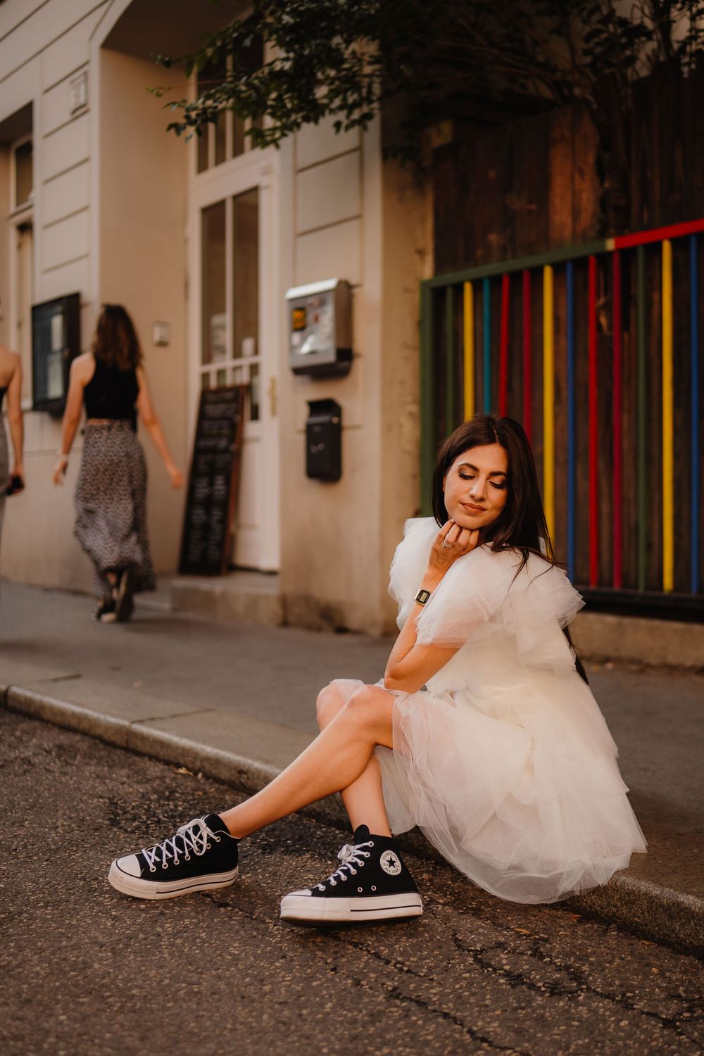 Street fashion photo of white tulle dress paired with classic black sneakers.