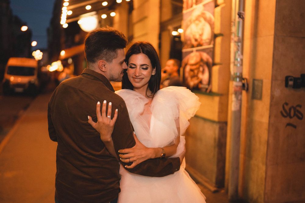 Warm-toned evening street scene with couple sharing intimate moment.