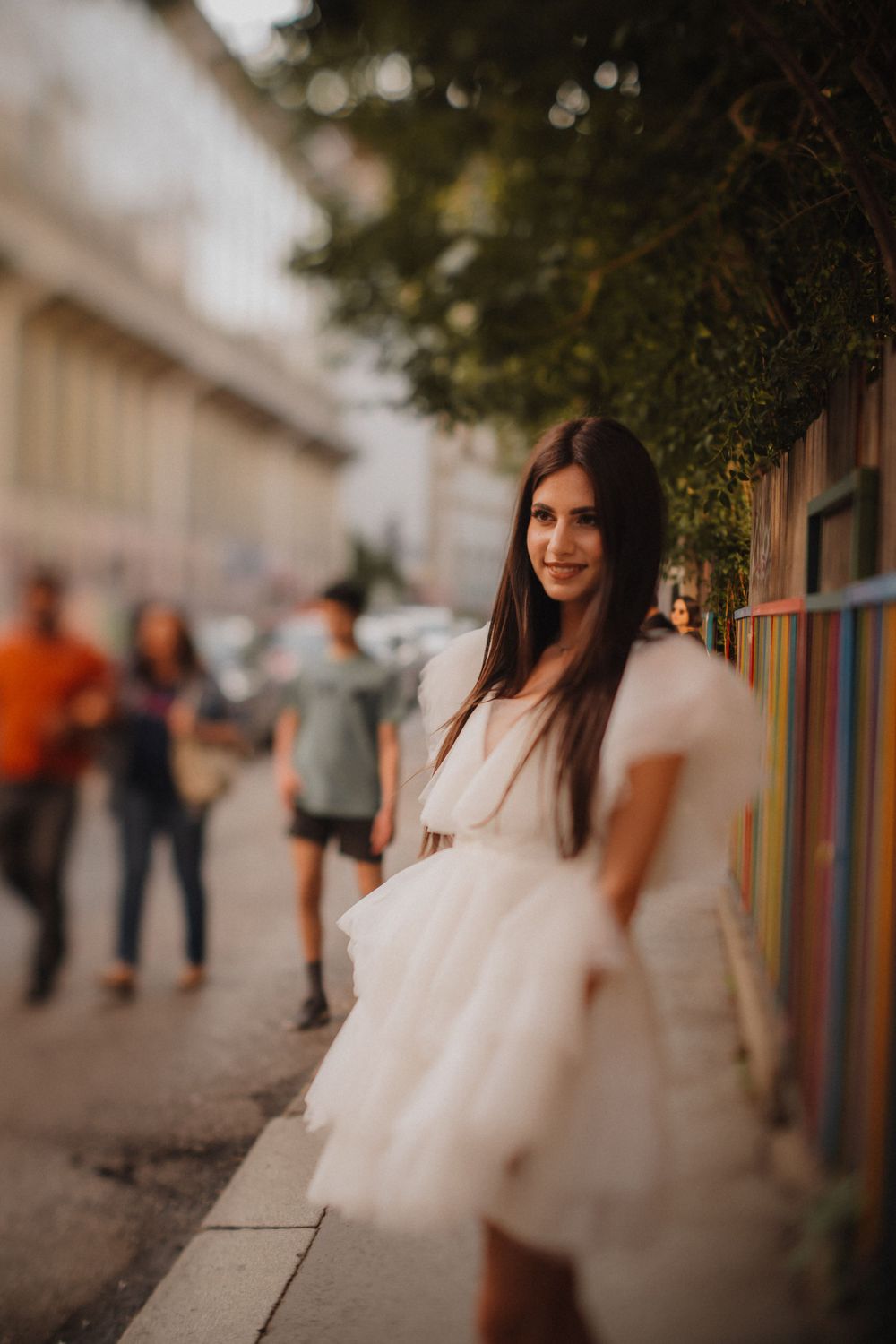 Urban fashion shoot featuring flowy white dress against colorful wall mural.