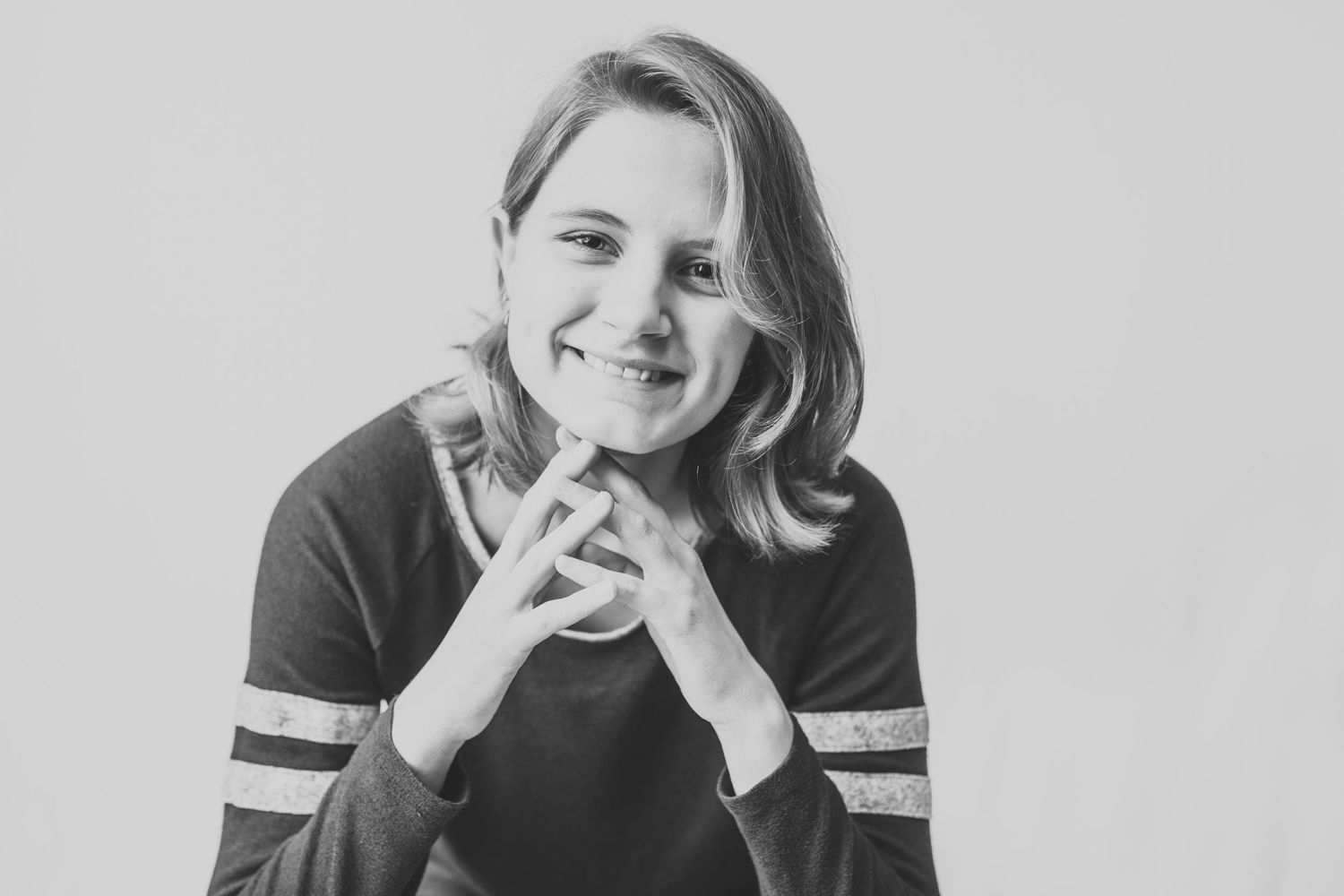 Black and white portrait showing joyful expression in striped sleeve top.