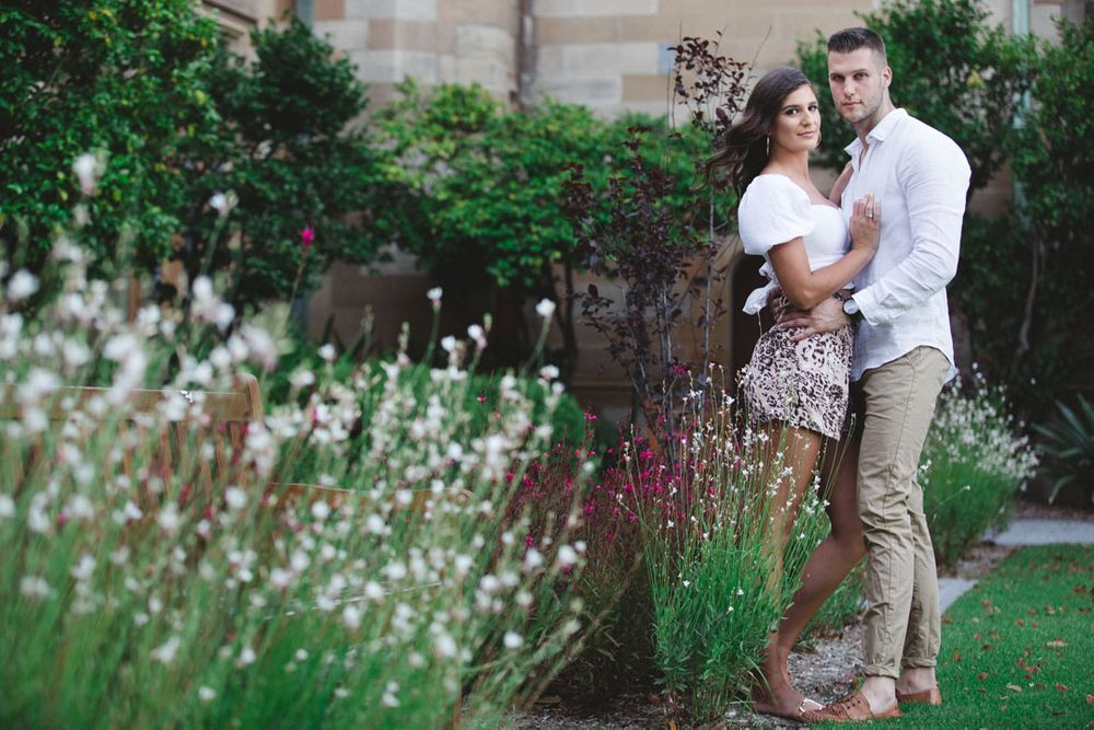 A romantic moment captured among flowering gardens and stone architecture.