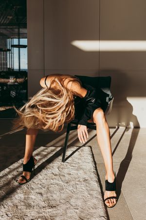 A woman sat on a chair with her hair moving in a luxury villa in Mallorca, Spain