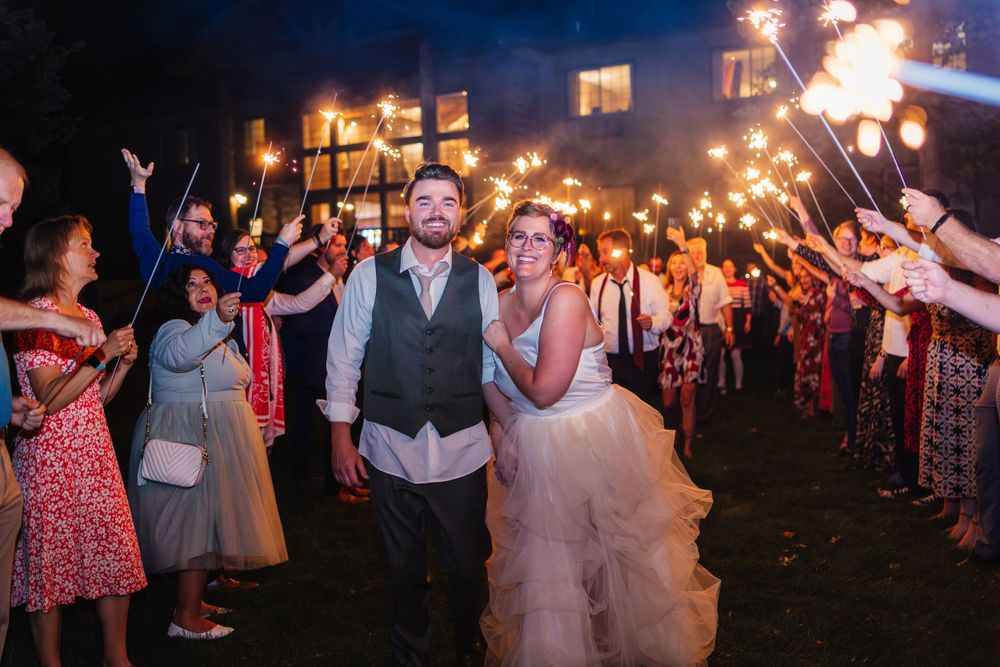 Wedding celebration at night with sparklers creating a magical atmosphere for the newlyweds.