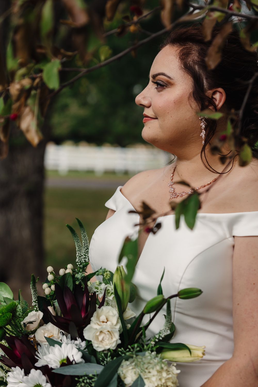 A bridal portrait featuring an elegant bouquet with white and burgundy flowers.