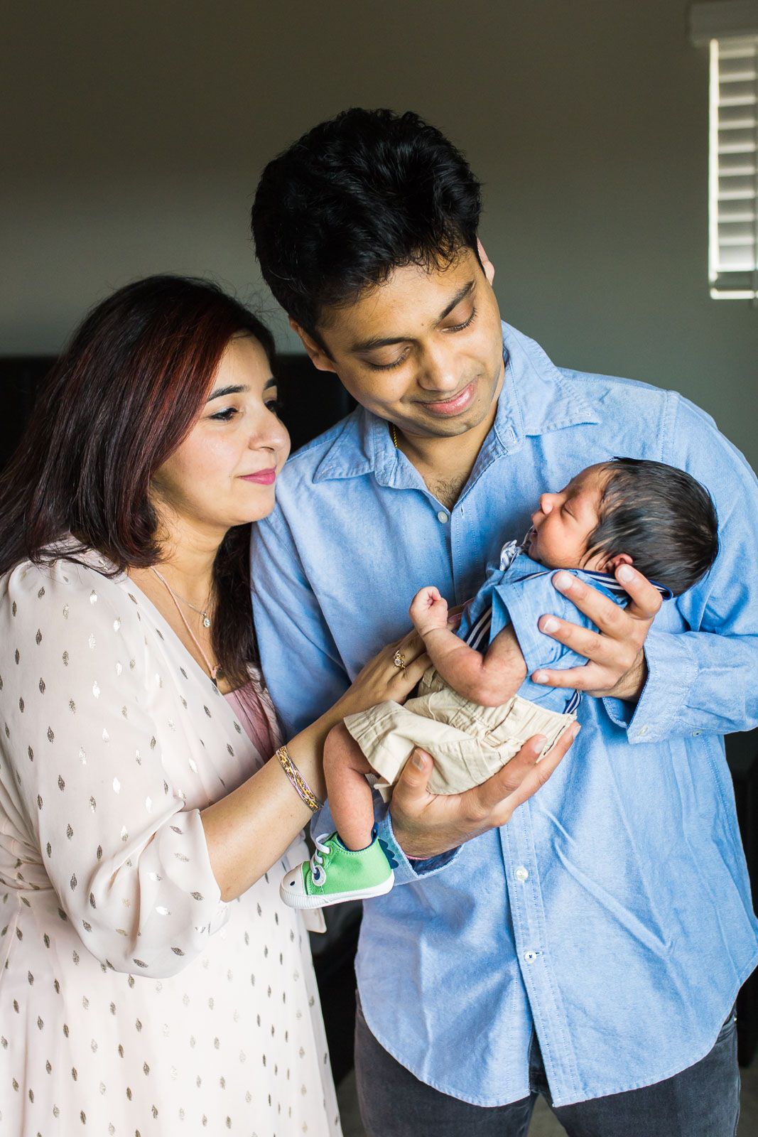 Parents holding their newborn son lovingly at home