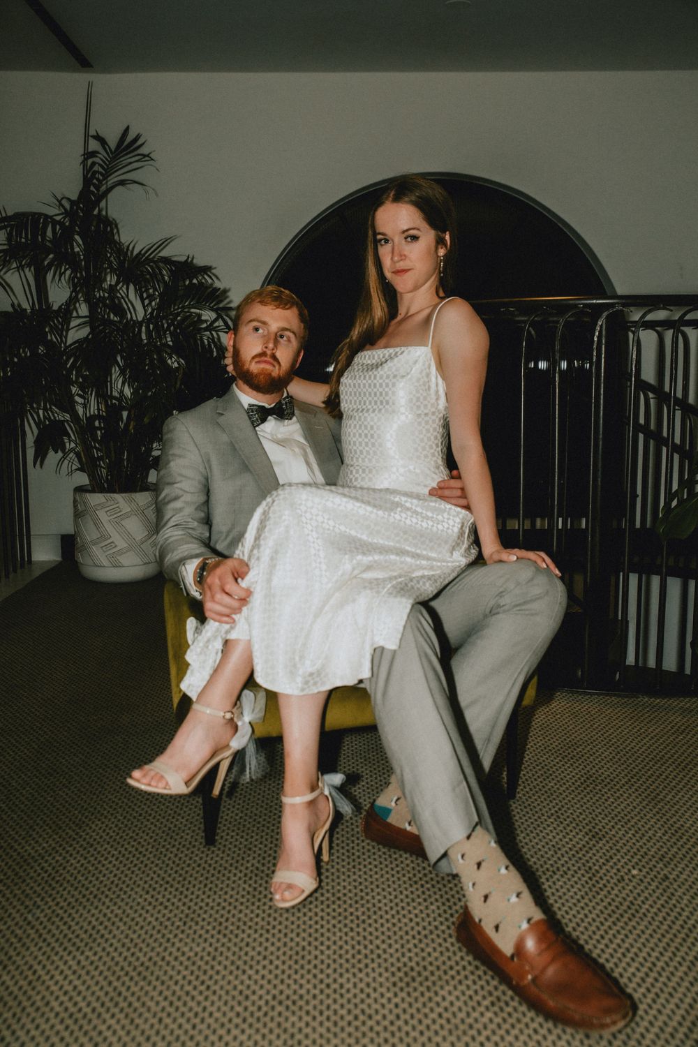 A man and a woman pose in an armchair