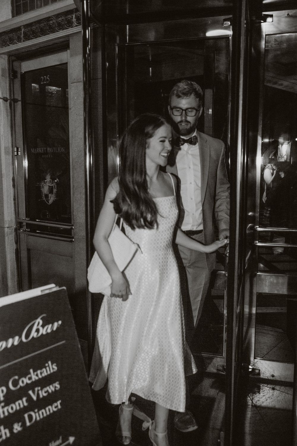 A photo of a couple exiting a revolving door