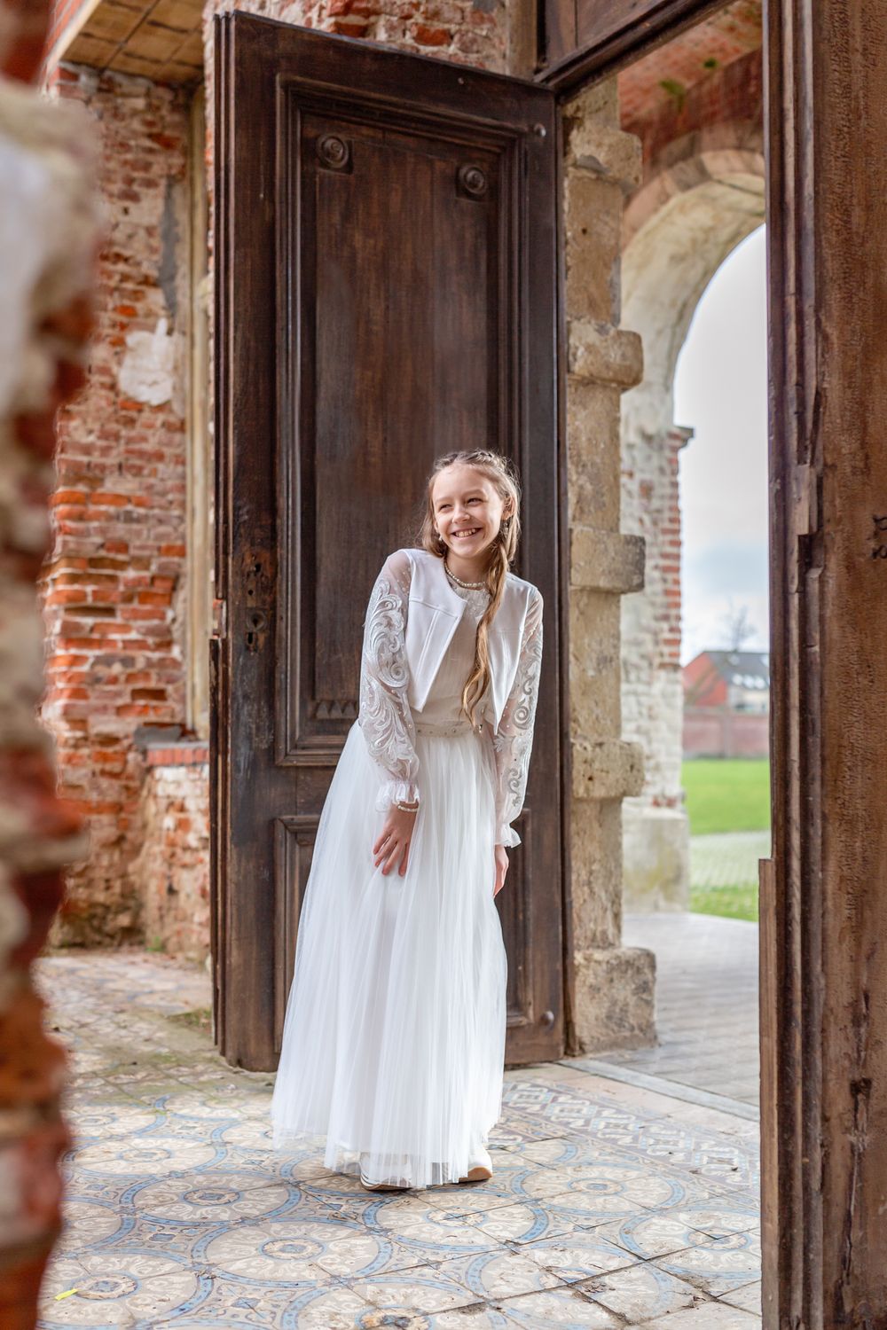 Candid moment captured in an old doorway featuring someone in a flowing white dress.
