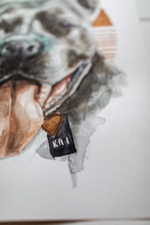 A detailed watercolor painting of a dog's face with a name tag visible.