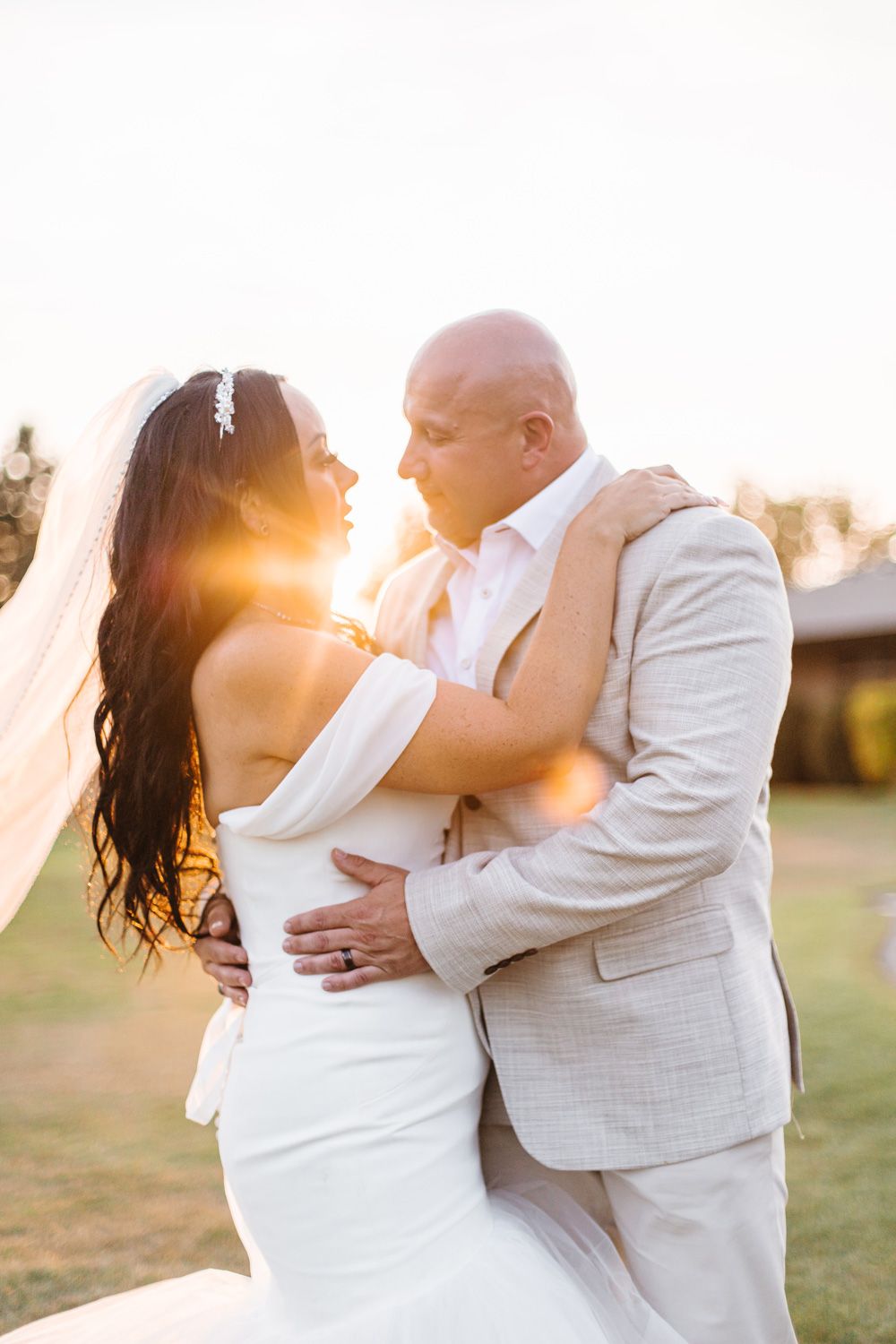 Golden hour wedding photos capturing tender embraces between the newlyweds.