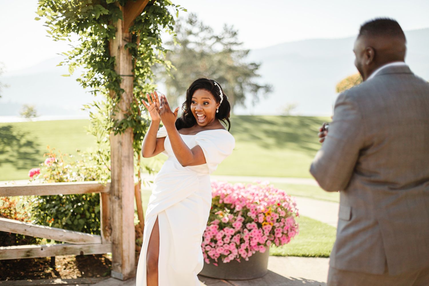 A romantic wedding photo session takes place in a garden with pink floral accents.
