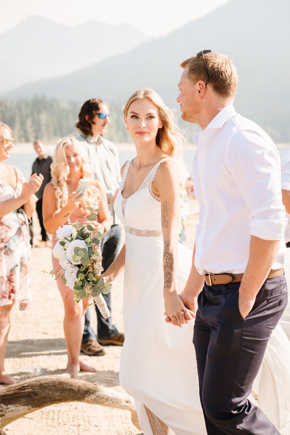 Candid moments captured during a beach wedding with guests in casual attire.