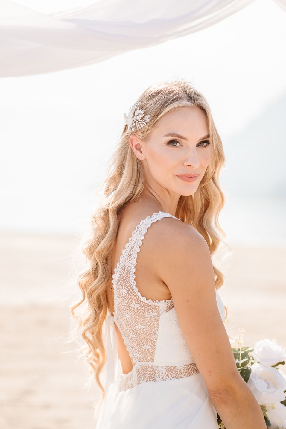 Side profile view of wedding dress showing delicate lace overlay.